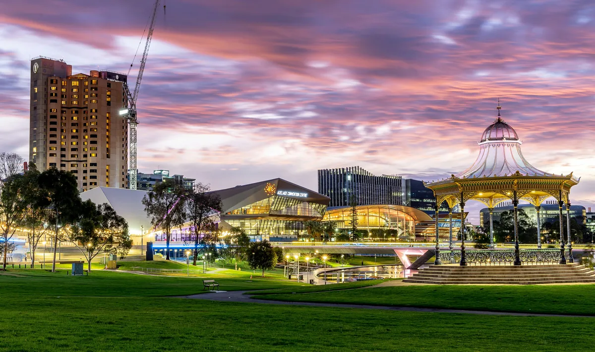 A park with a carousel and buildings in the background