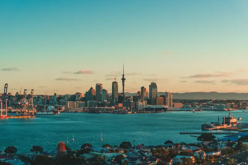 The Auckland skyline and harbor under a warm low sun in New Zealand