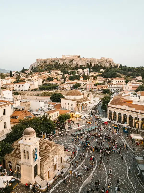 A crowd of people in Monastiraki Square with the Acropolis in Athens, Greece