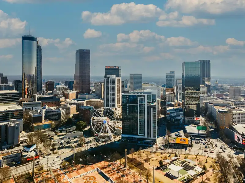 A view of a city with a ferris wheel in the foreground