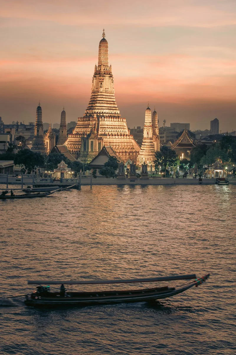 A boat in the water with a large building in the background
