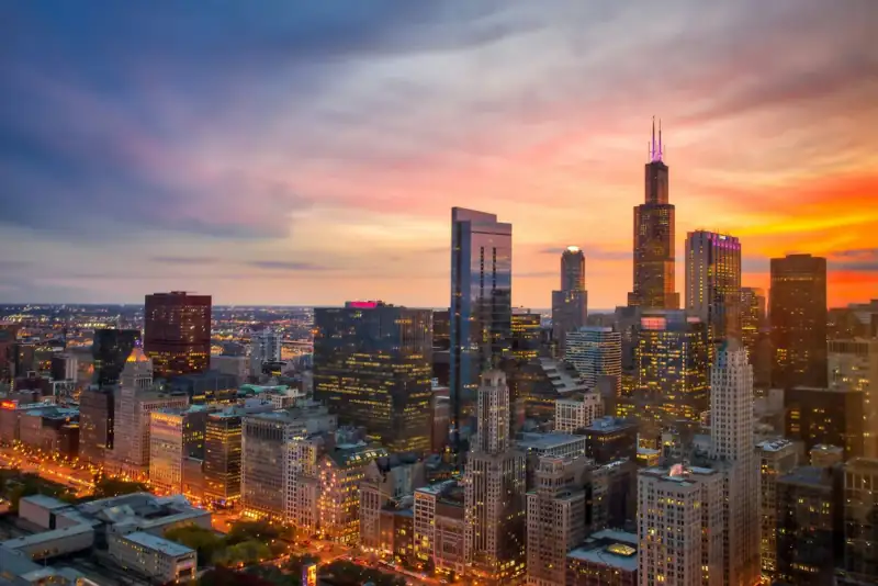 A view of a city at sunset from the top of a skyscraper