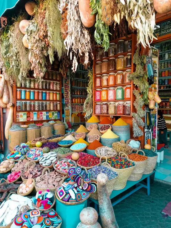 Baskets of colorful spices and dried flowers in a traditional Moroccan market stall