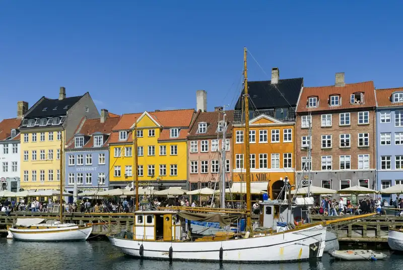 Colorful buildings line a harbor with boats