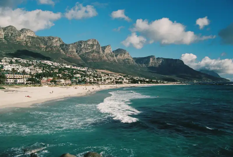 Scenic beach, ocean, and town under majestic mountains
