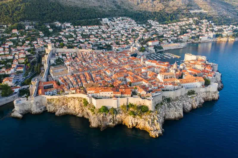 Aerial view of city buildings near body of water during daytime
