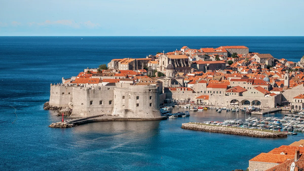 White and red concrete houses beside sea