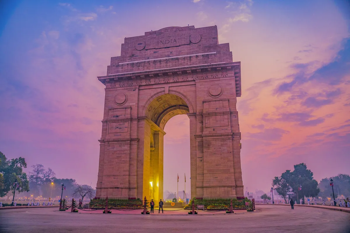 The India Gate war memorial in New Delhi under a vibrant pink sky