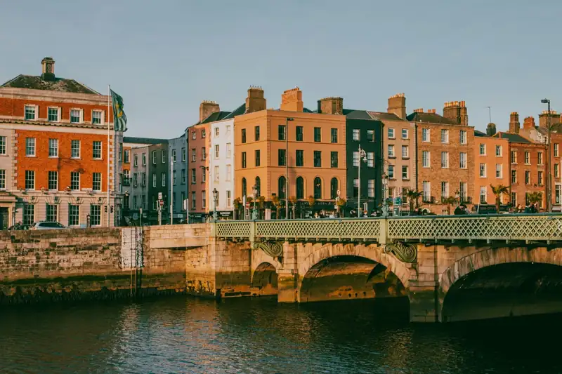 A bridge over a body of water with buildings in the background