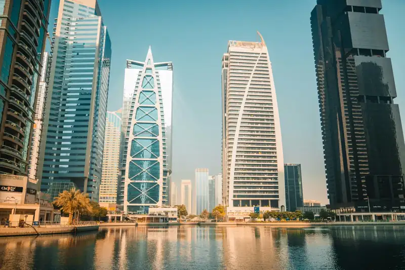 Modern skyscrapers reflect on the water in a city