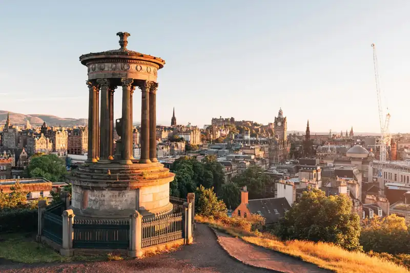 The Dugald Stewart Monument overlooking the Edinburgh skyline at golden hour