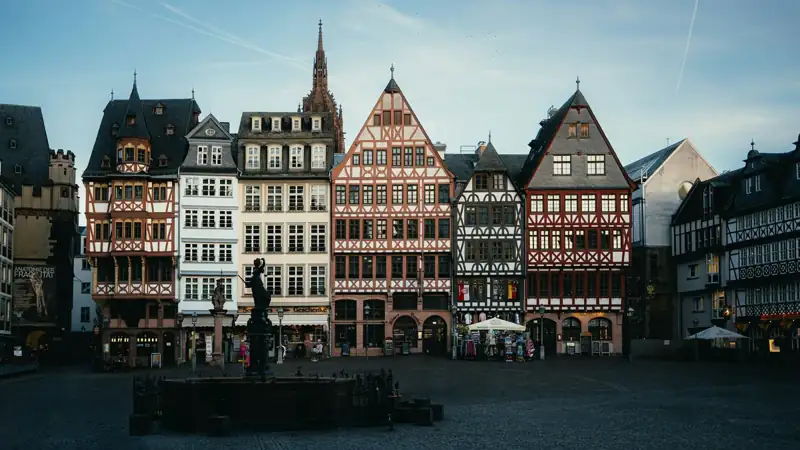 Historic buildings line a european city square at dusk