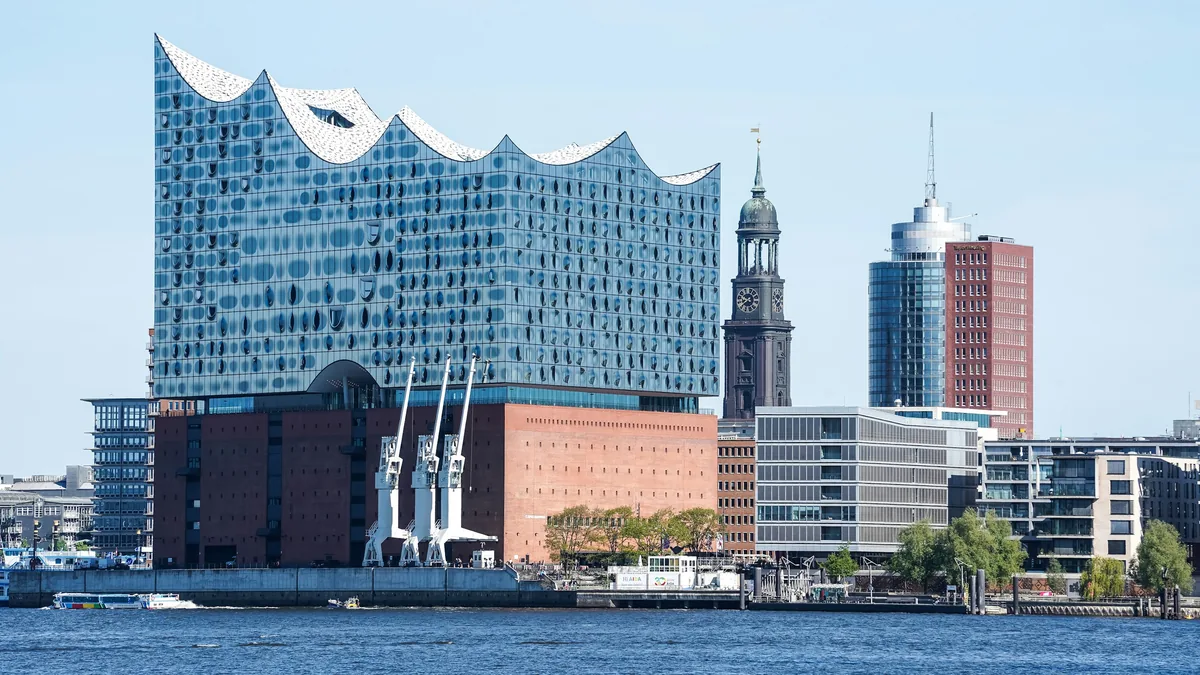 Modern buildings and a church tower by the water