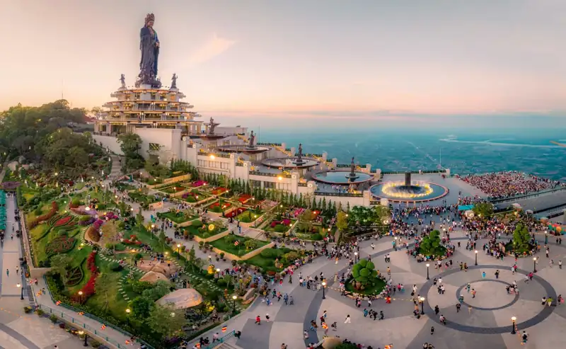 Large statue overlooking a scenic garden and ocean