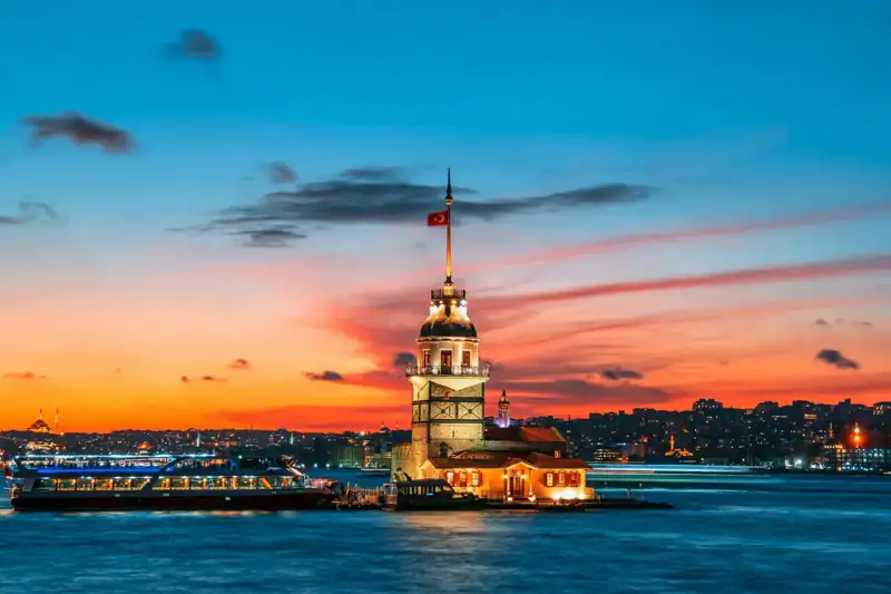 The Maiden Tower on the Bosphorus in Istanbul under a vibrant orange sky