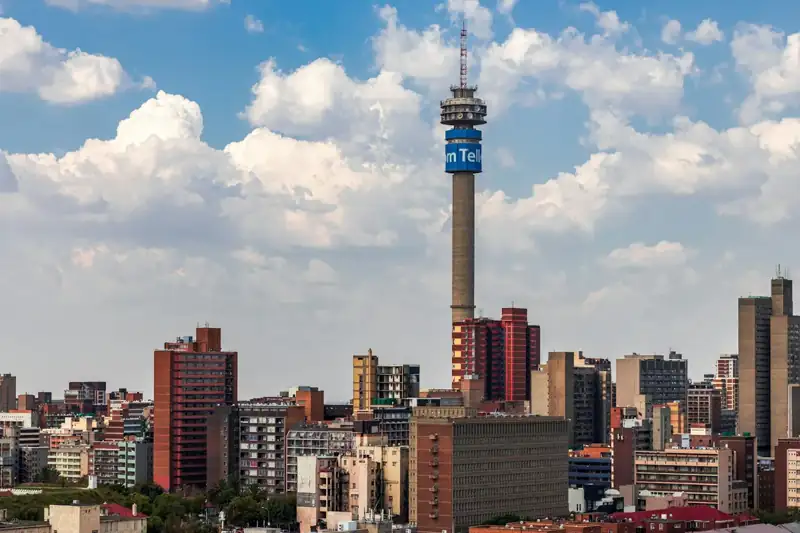 City skyline under blue and white cloudy sky during daytime