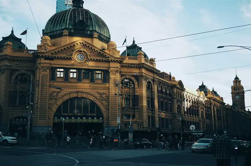 Brown building with cars passing infront