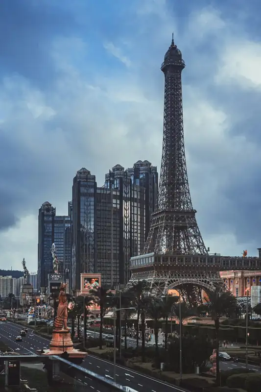 Eiffel tower replica and modern buildings under a cloudy sky