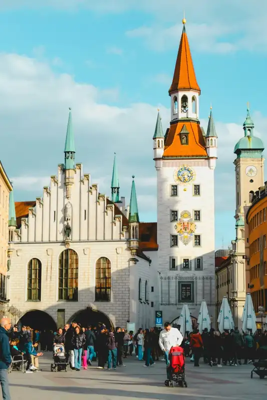 People gather in a european square with ornate buildings