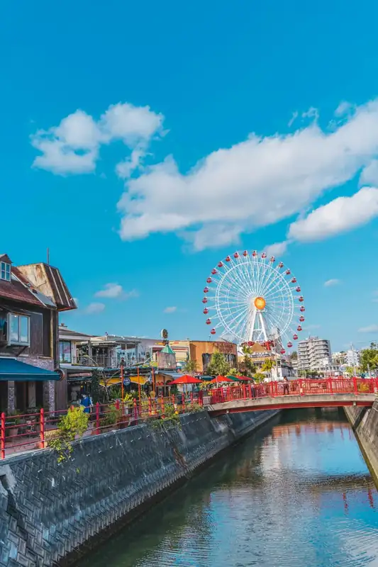 A ferris wheel on a bridge over a body of water