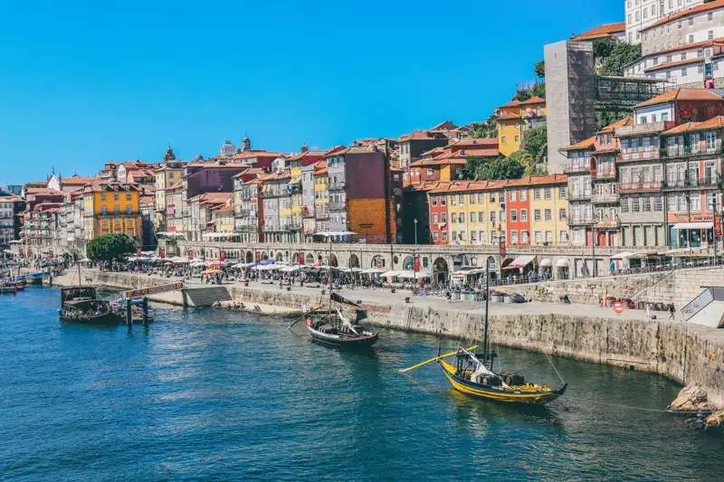 Traditional wooden boats on the Douro River in Porto, Portugal, with colorful buildings