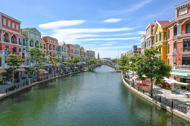 Colorful buildings line a canal with a bridge