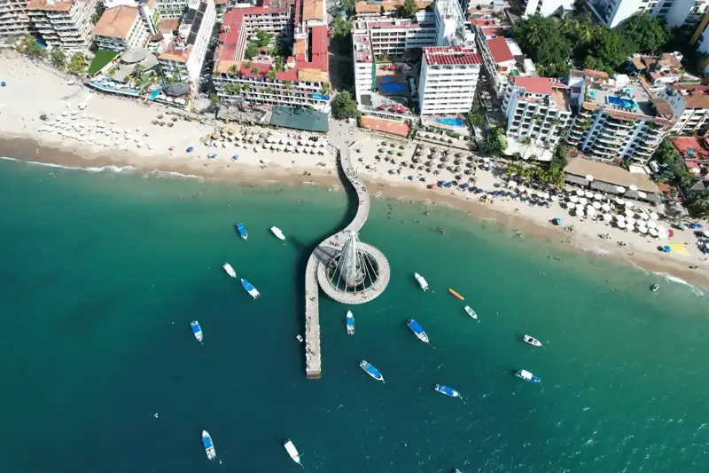 An aerial view of a beach with boats in the water