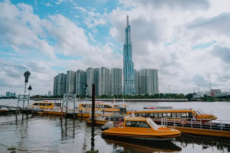 White and brown boat on water near city buildings during daytime