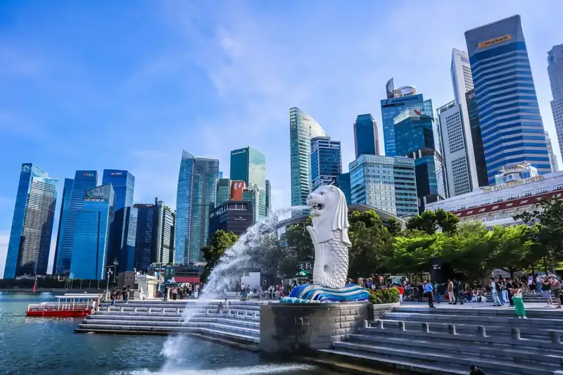 Merlion statue with singapore skyline and blue sky