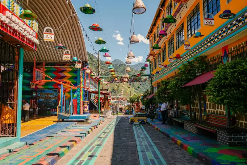 A vibrant, colorful street with decorated buildings and hanging ornaments