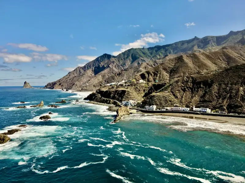 A scenic view of the ocean with mountains in the background