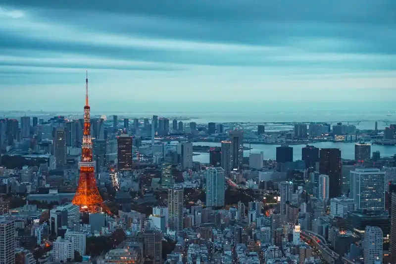 Tokyo tower illuminated at dusk with city skyline