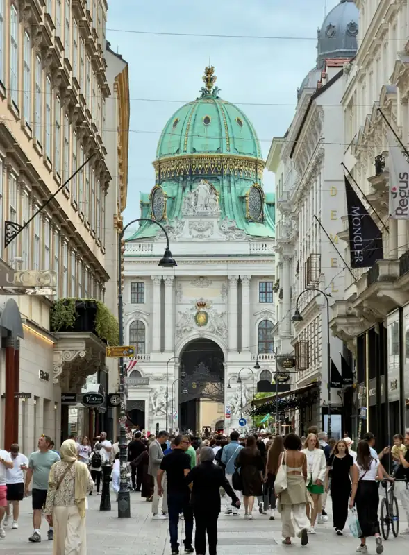 Bustling street scene with a grand building and green dome