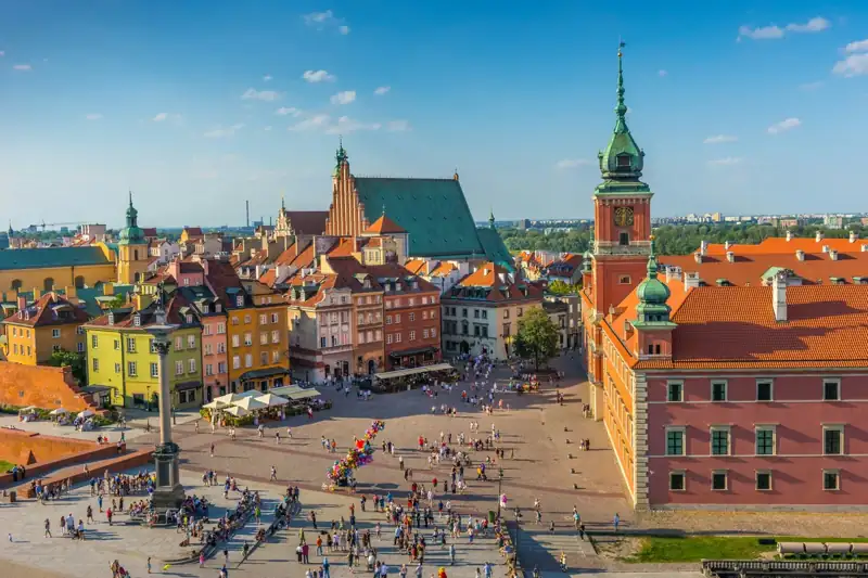 Historic city square with colorful buildings and many people