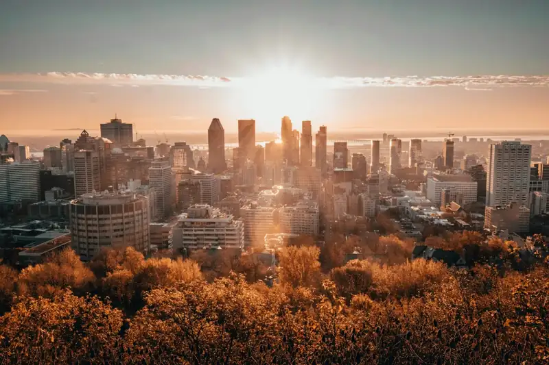 The sun is setting over a city with tall buildings