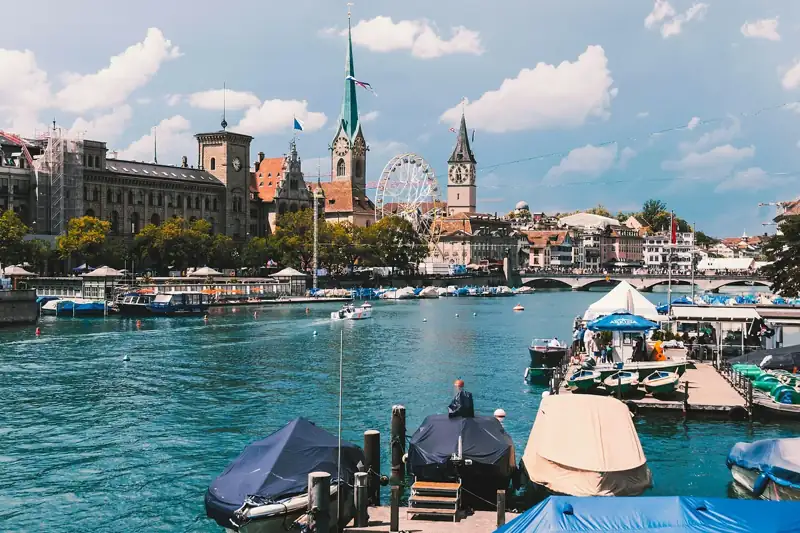 A body of water with boats and buildings in the background